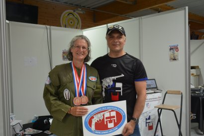 Nadia, une adhérente doublement médaillée (811 individuel et par équipes) pour le plus grand plaisir du Club de tir grenoblois, pose devant le stand UFA avec Arthur. 